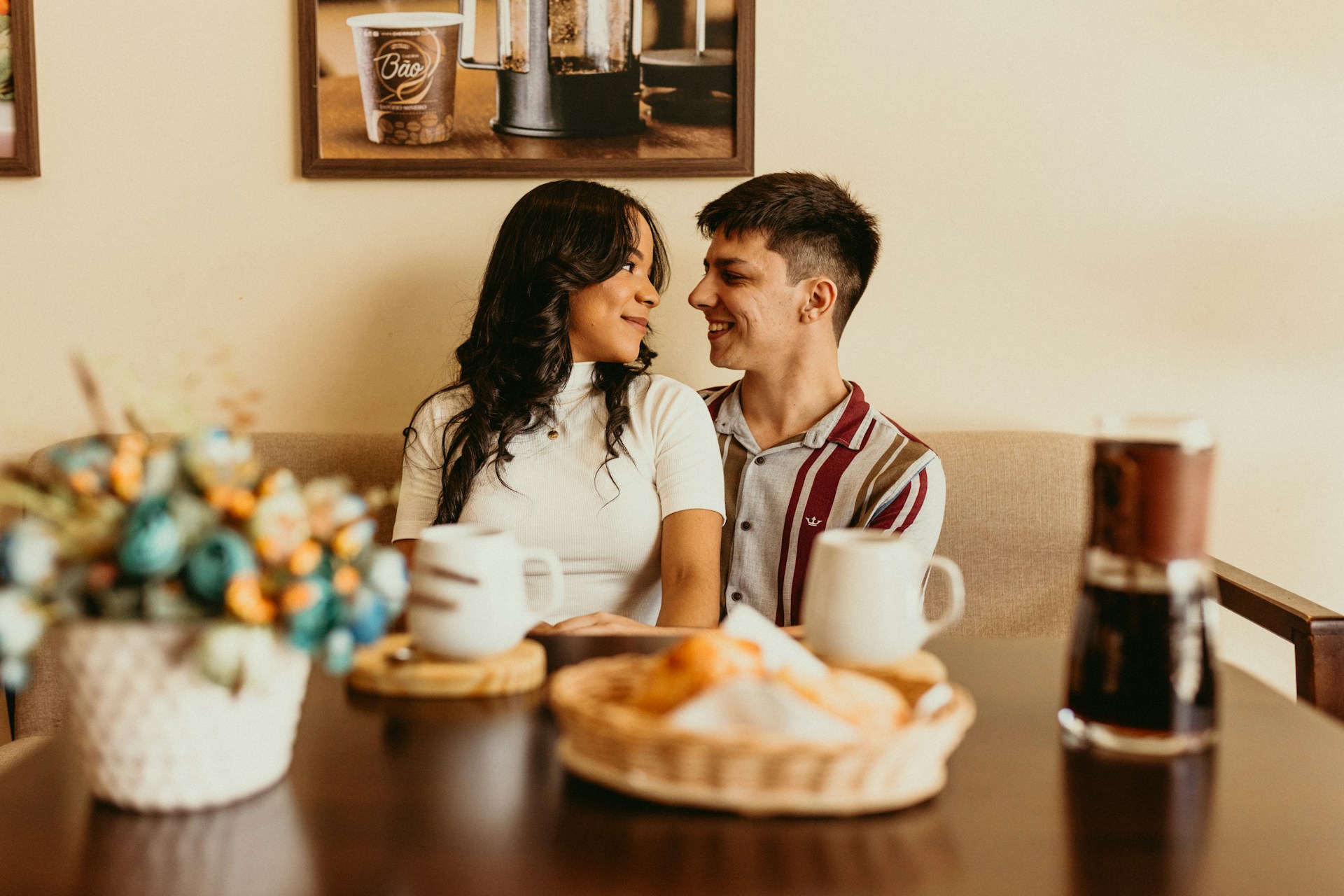 Couple laughing together at kitchen table with coffee
