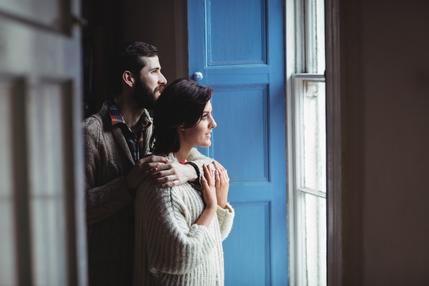 Couple hugging warmly greeting at door