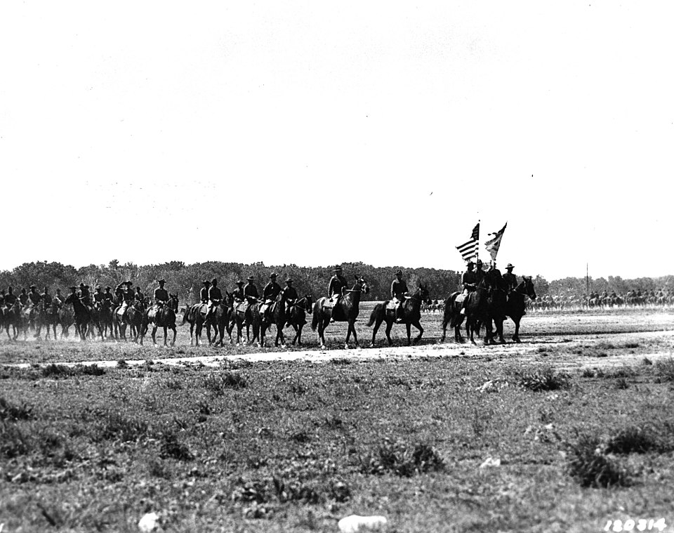 With colors flying and guidons down, the lead troops of the famous 9th Cavalry pass in review at the regiment's new home in rebuilt Camp Funston, Ft. Riley, Kansas, May 1941.