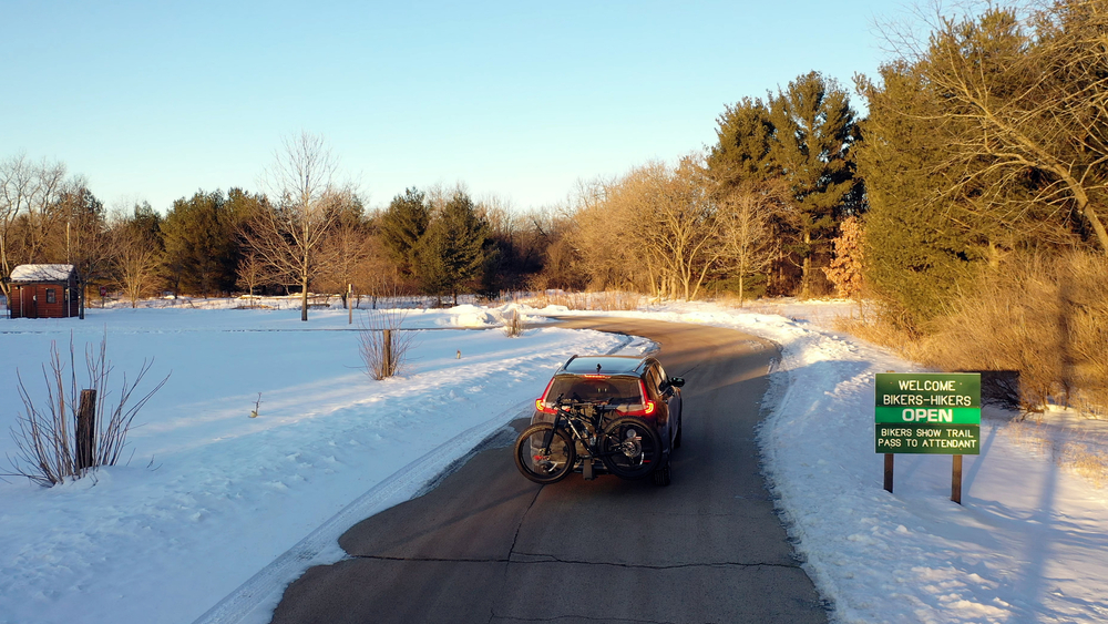 Kettle Moraine State forest, Wisconsin, USA - January 24 2021: Entrance to John Muir Hiking Biking Trails in Kettle Moraine State forest in Wisconsin in winter. Black SUV car with a fat bike